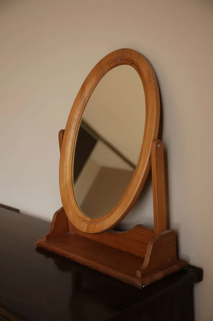 An oval mirror in a wooden frame photo 1